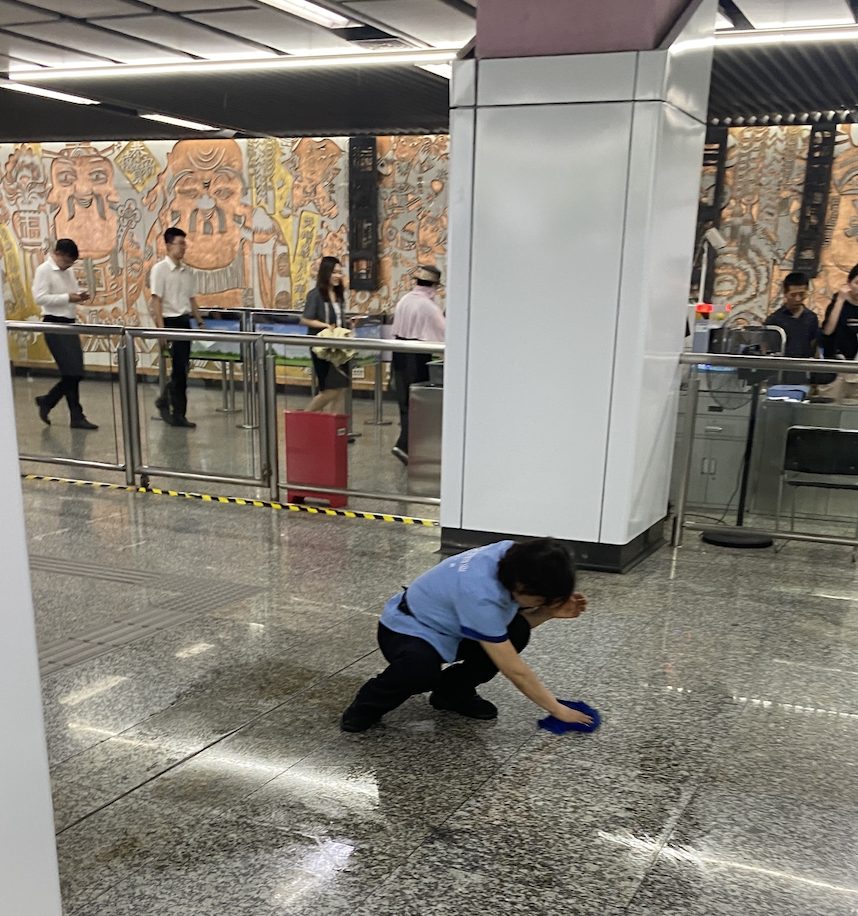 南京地铁站里蹲在地上擦地板的保洁员,我拍的实景