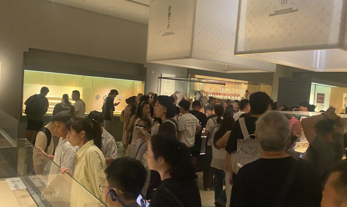 南京博物院展厅内人山人海,热门展柜前围满观众,我拍的实景