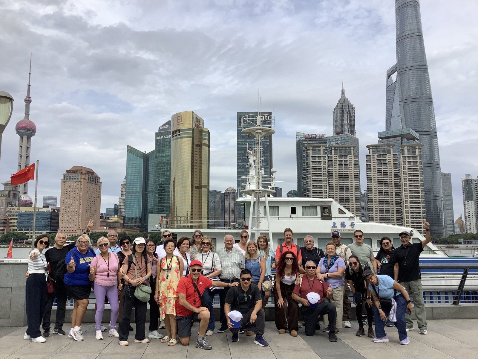 加拿大旅游团团员在上海外滩的合影，背后是黄浦江对岸的陆家嘴天际线